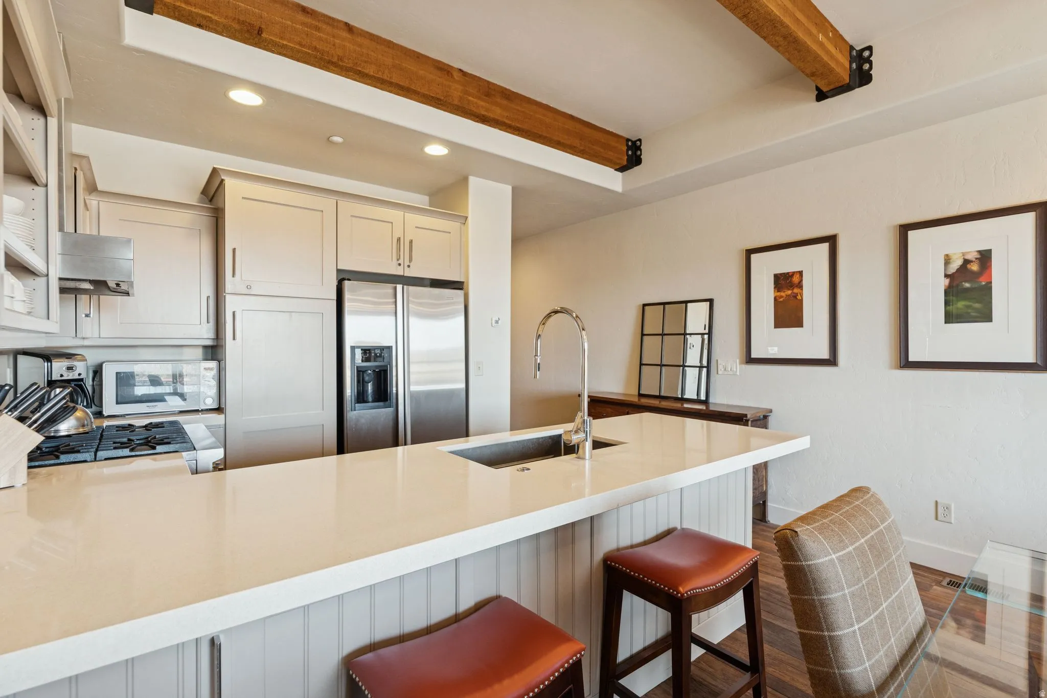 Kitchen featuring a central island with an undermount sink and gooseneck faucet