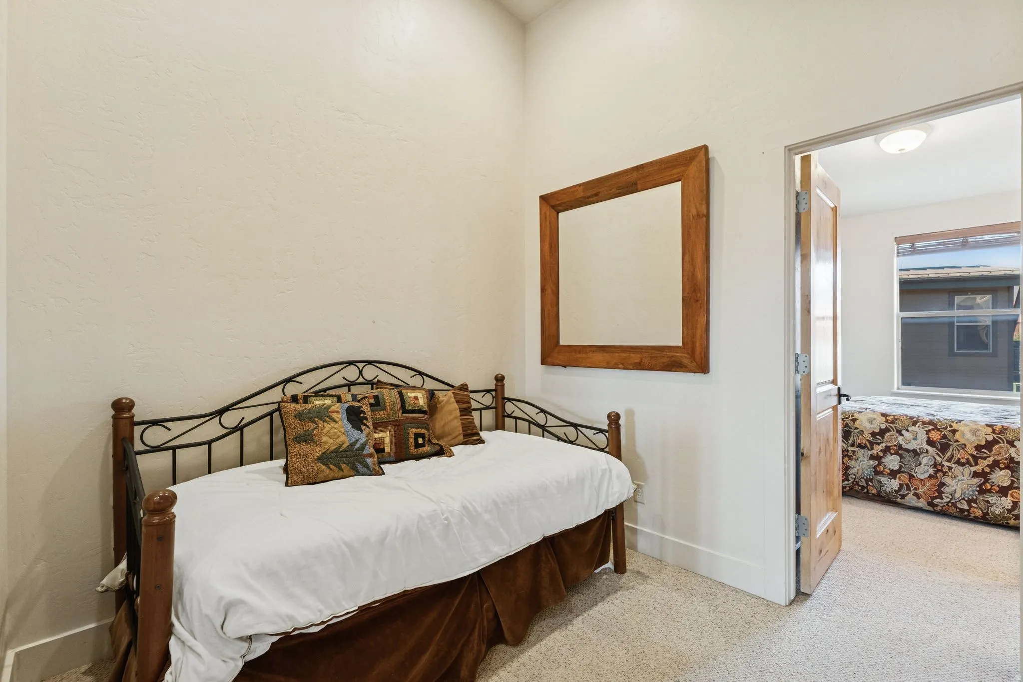 Bright interior room featuring a high ceiling, textured walls, and light-colored carpet flooring