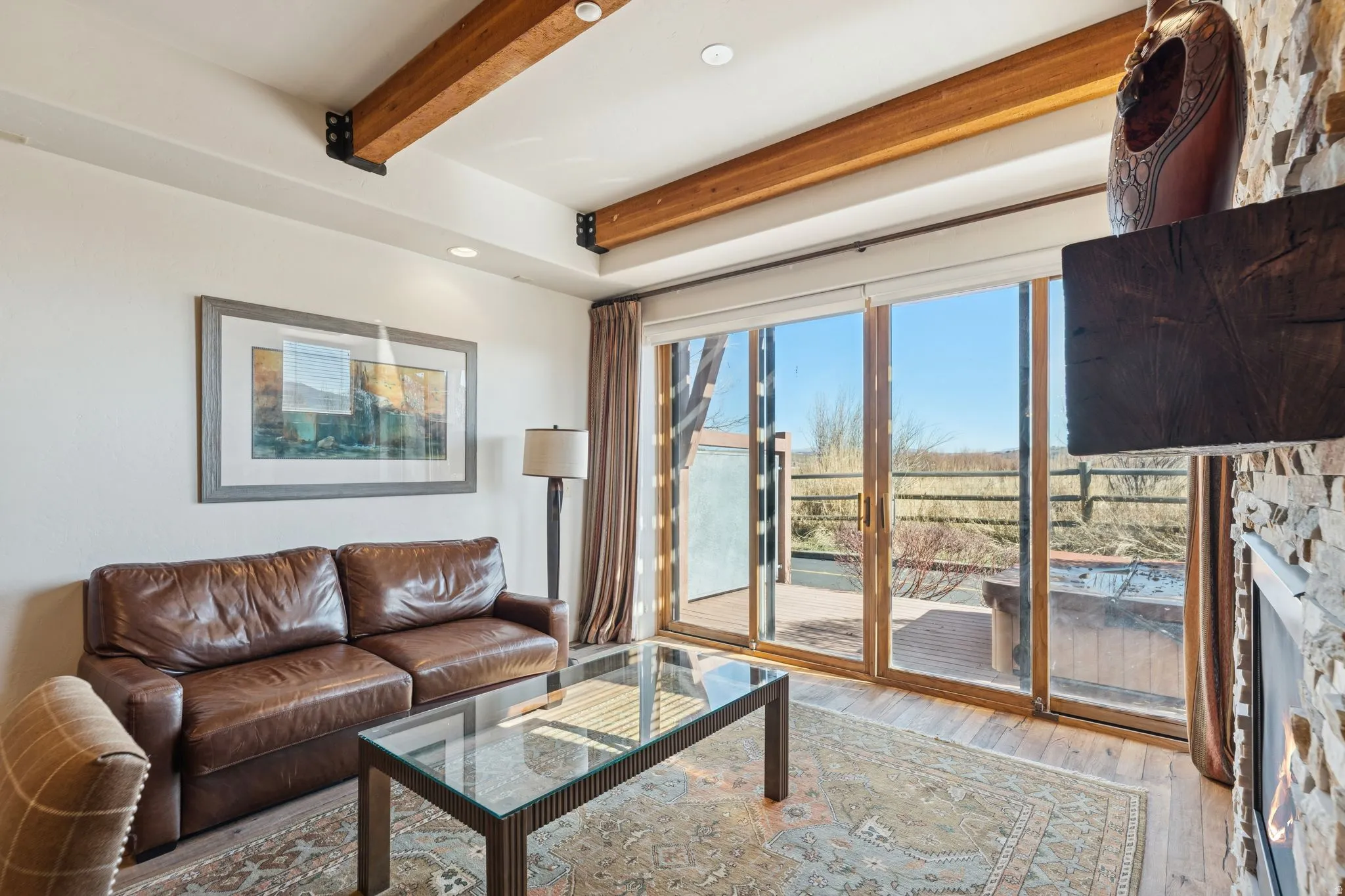 Living area with wood-finish flooring and exposed ceiling beams