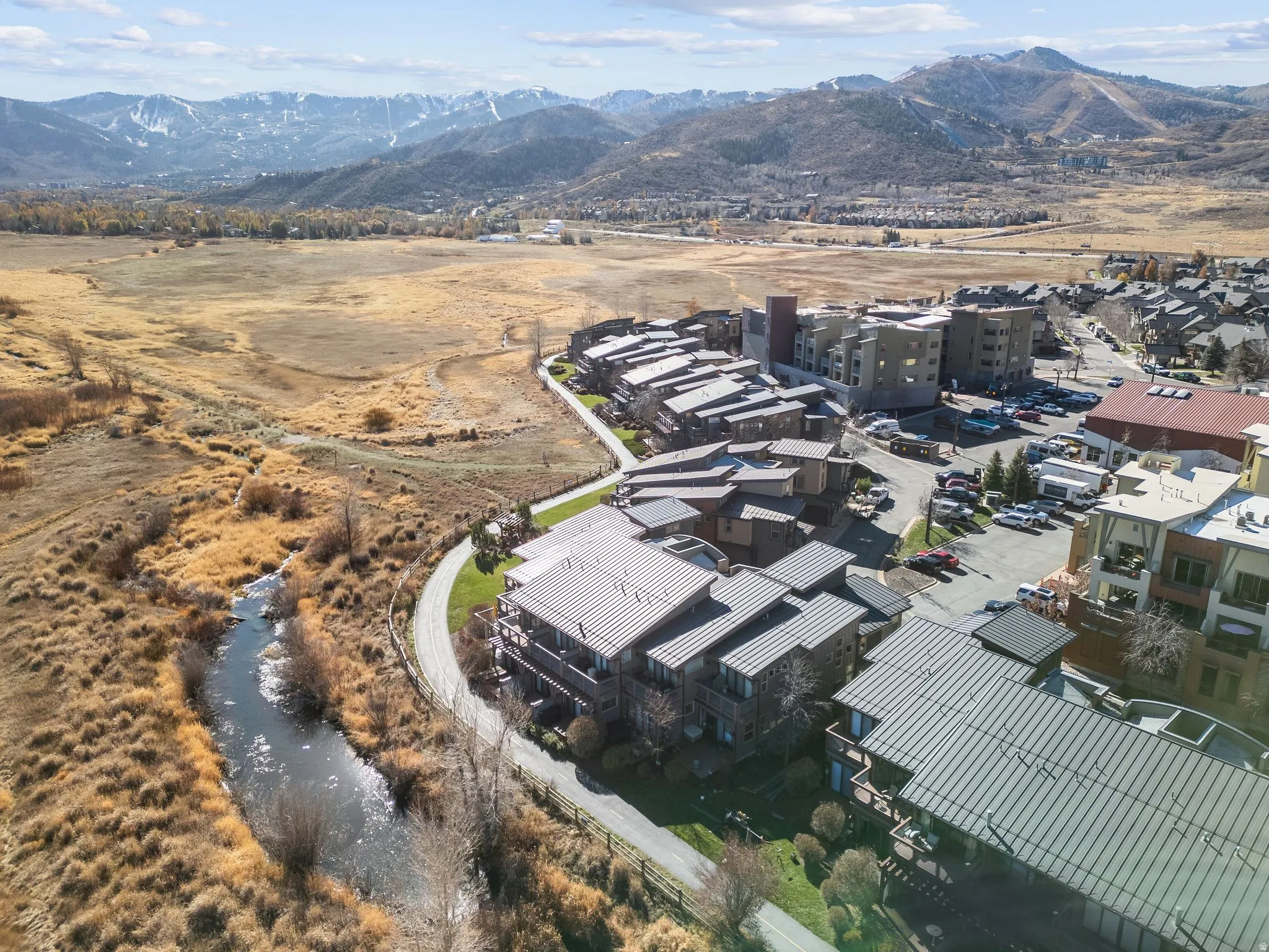 Aerial perspective showcasing a modern residential complex with multiple buildings featuring standing seam metal roofs and individual balconies