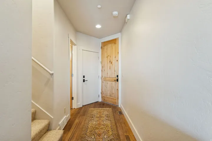Entryway featuring natural wood-finish flooring, recessed lighting, and a solid wood door with black hardware