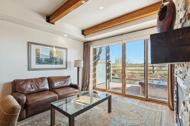 Living area with wood-finish flooring and exposed ceiling beams
