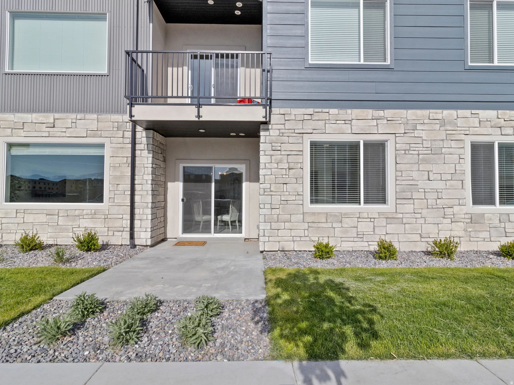 Doorway to property with stone siding and a lawn