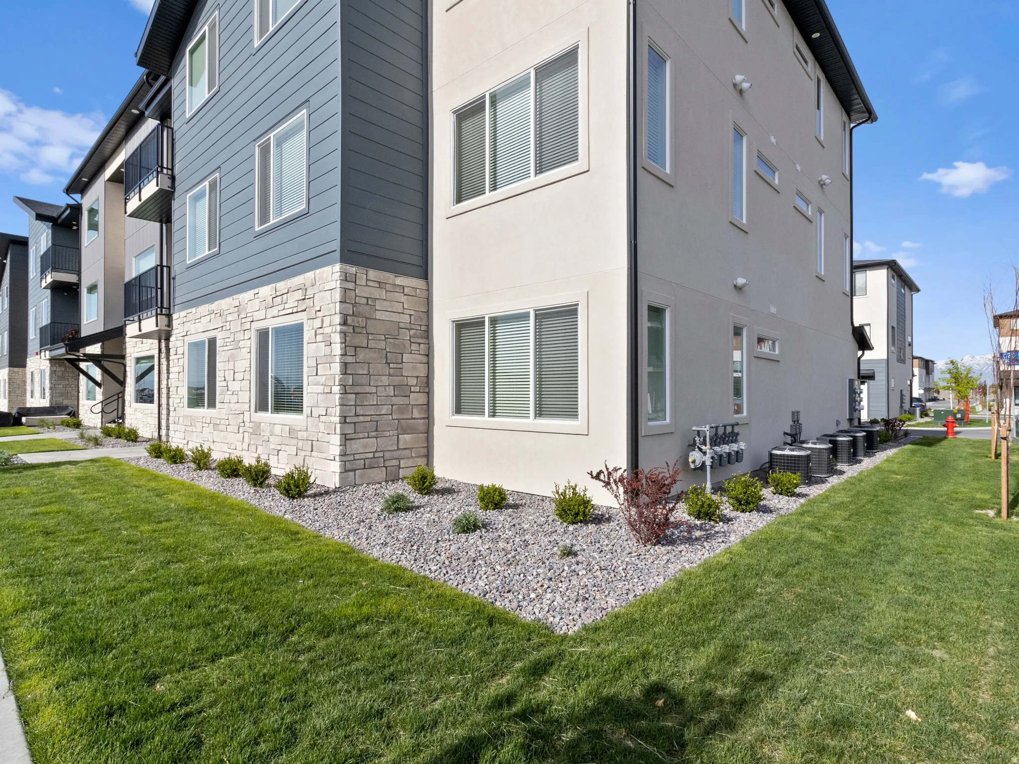 View of property exterior featuring stone siding and a yard