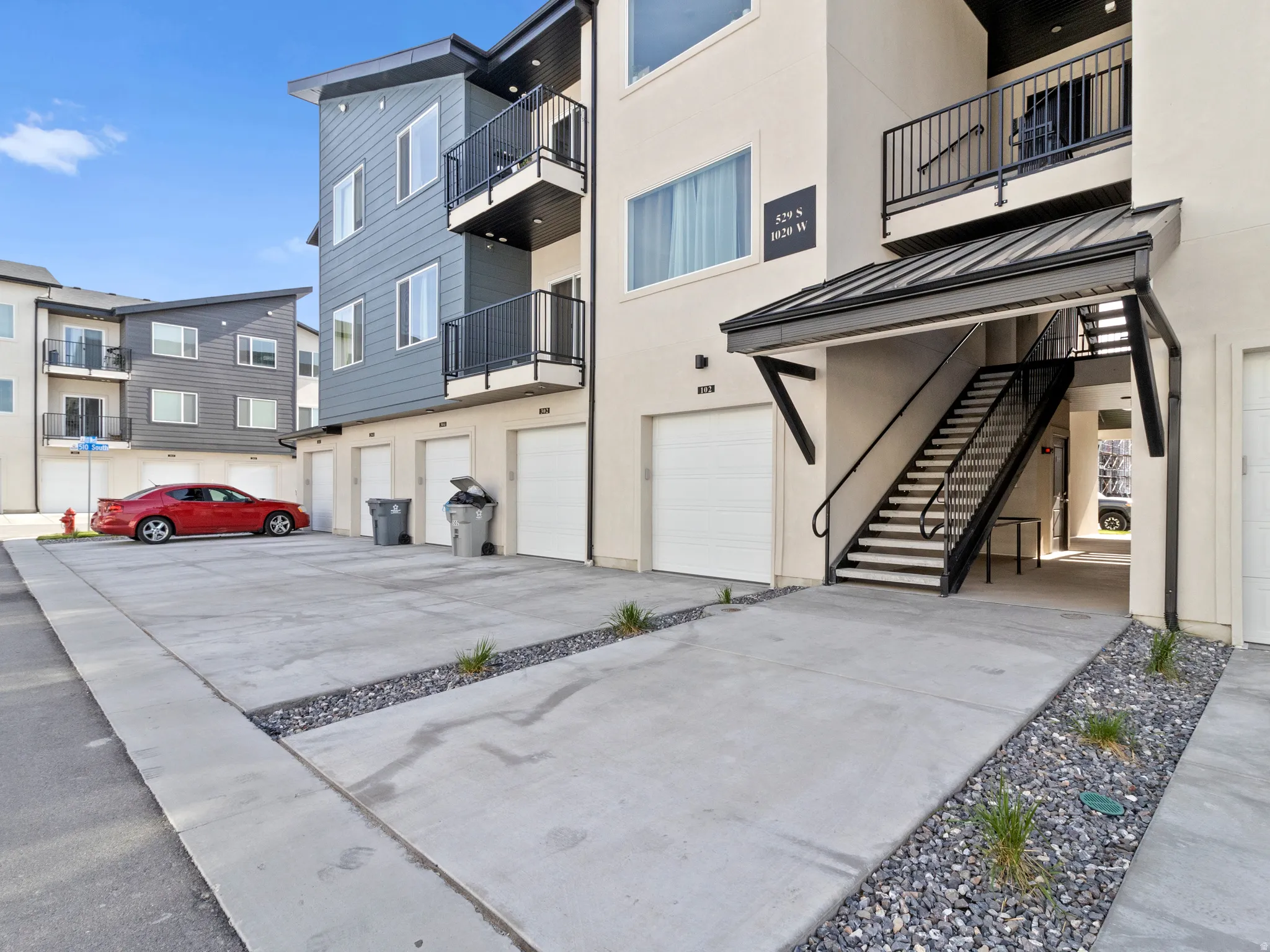 View of apartment building / complex featuring stairs and a garage