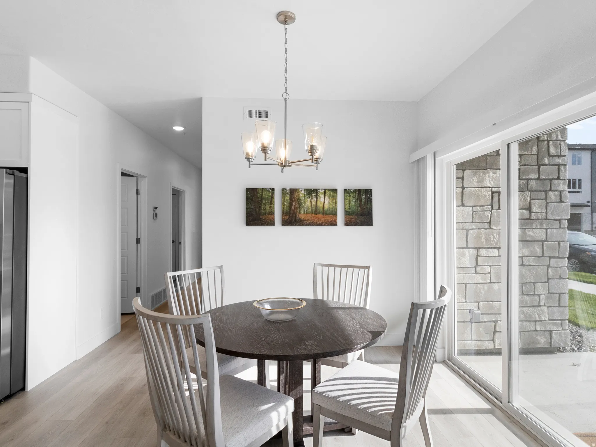 Dining room featuring light wood finished floors, a chandelier, and plenty of natural light