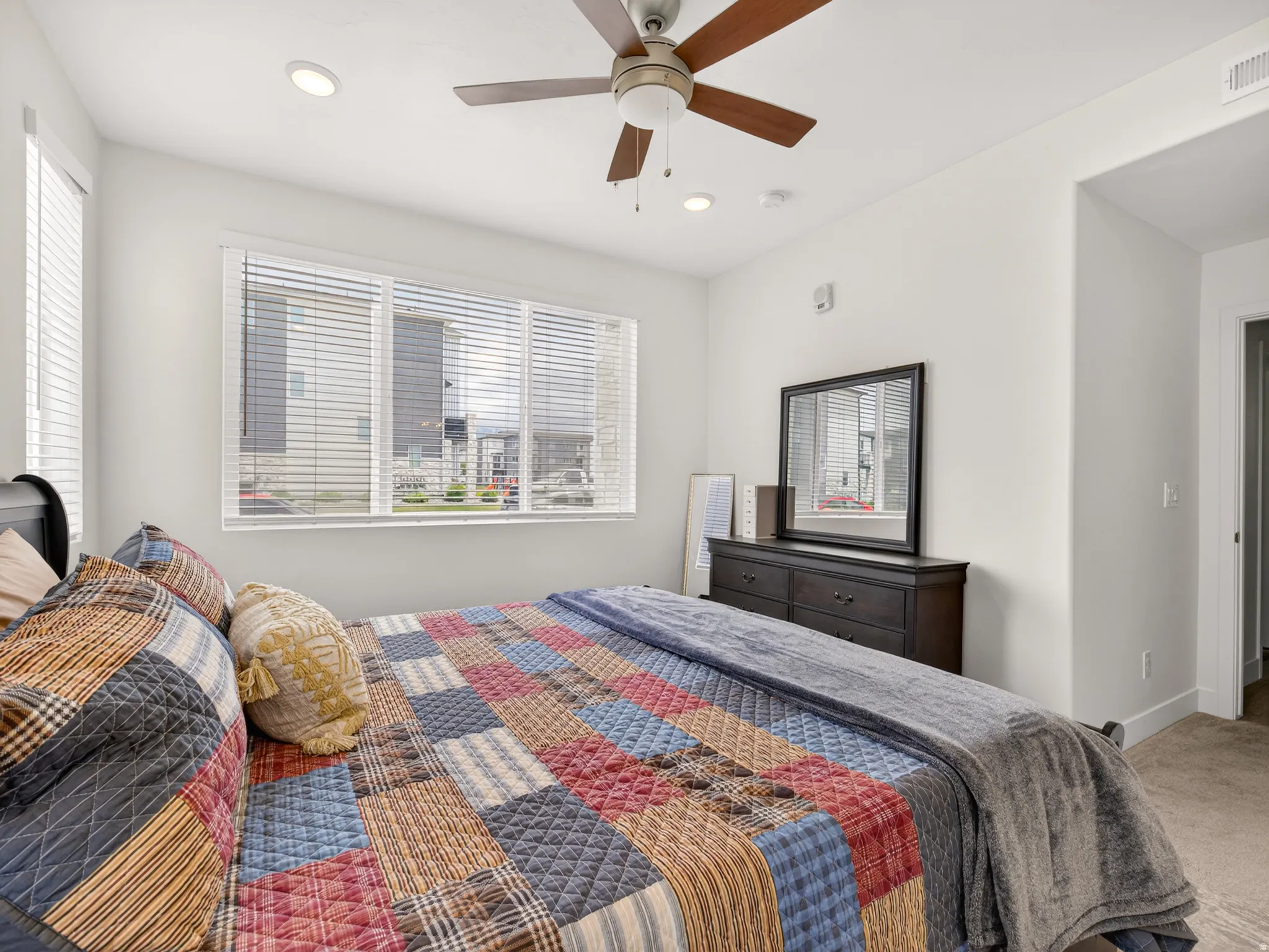 Bedroom featuring a large window with horizontal blinds, recessed lighting, and a ceiling fan