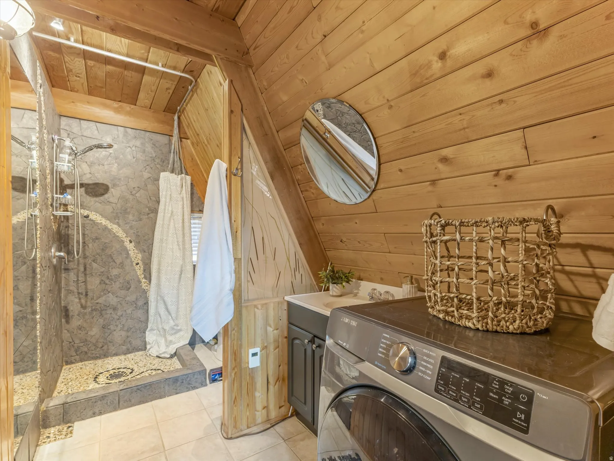 Laundry room with washer / dryer, wood walls, a vaulted wooden ceiling, and light tile patterned flooring