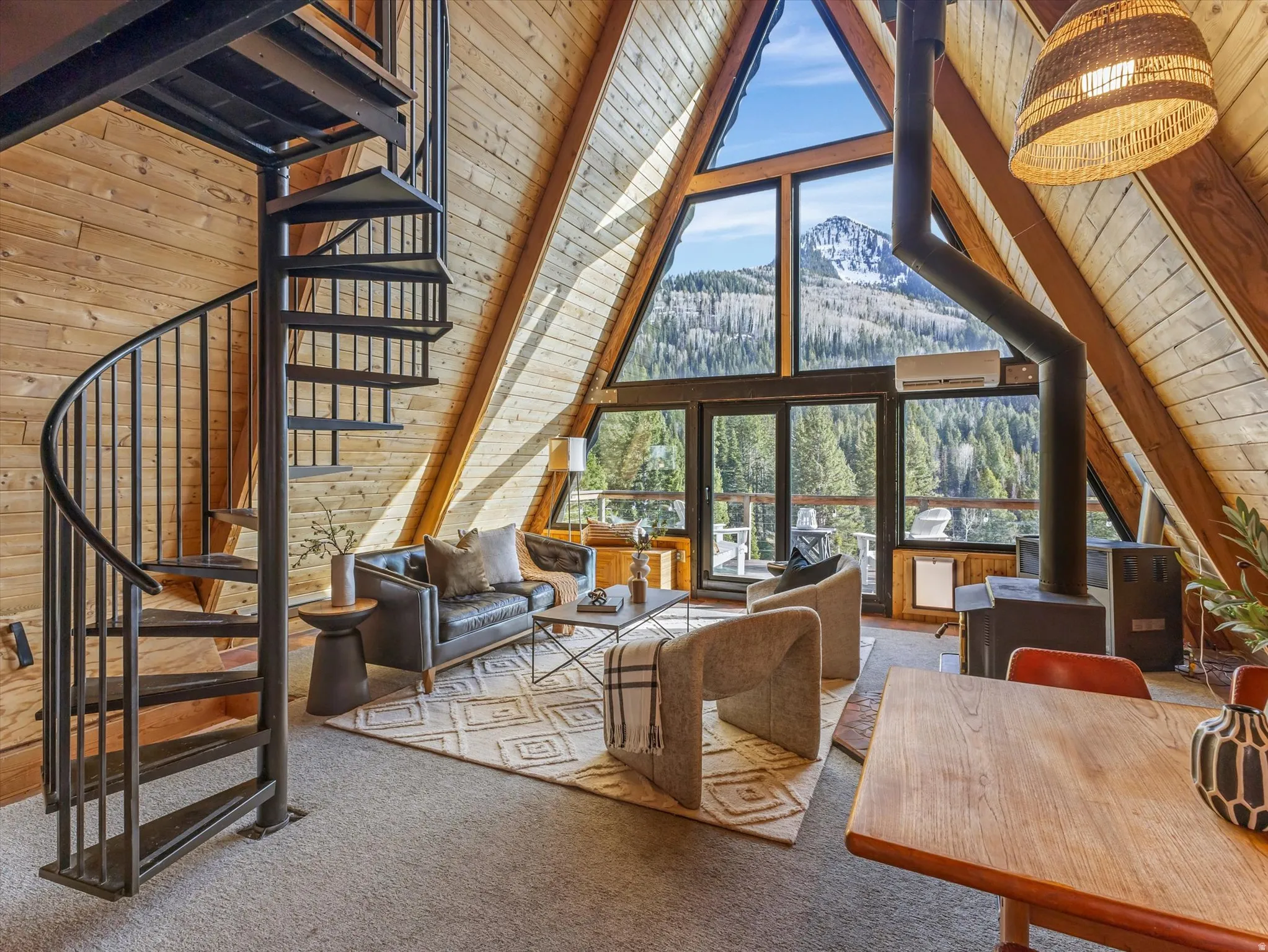 Carpeted living area featuring a wood stove, a high wooden beamed ceiling, wood walls, and a mountain view