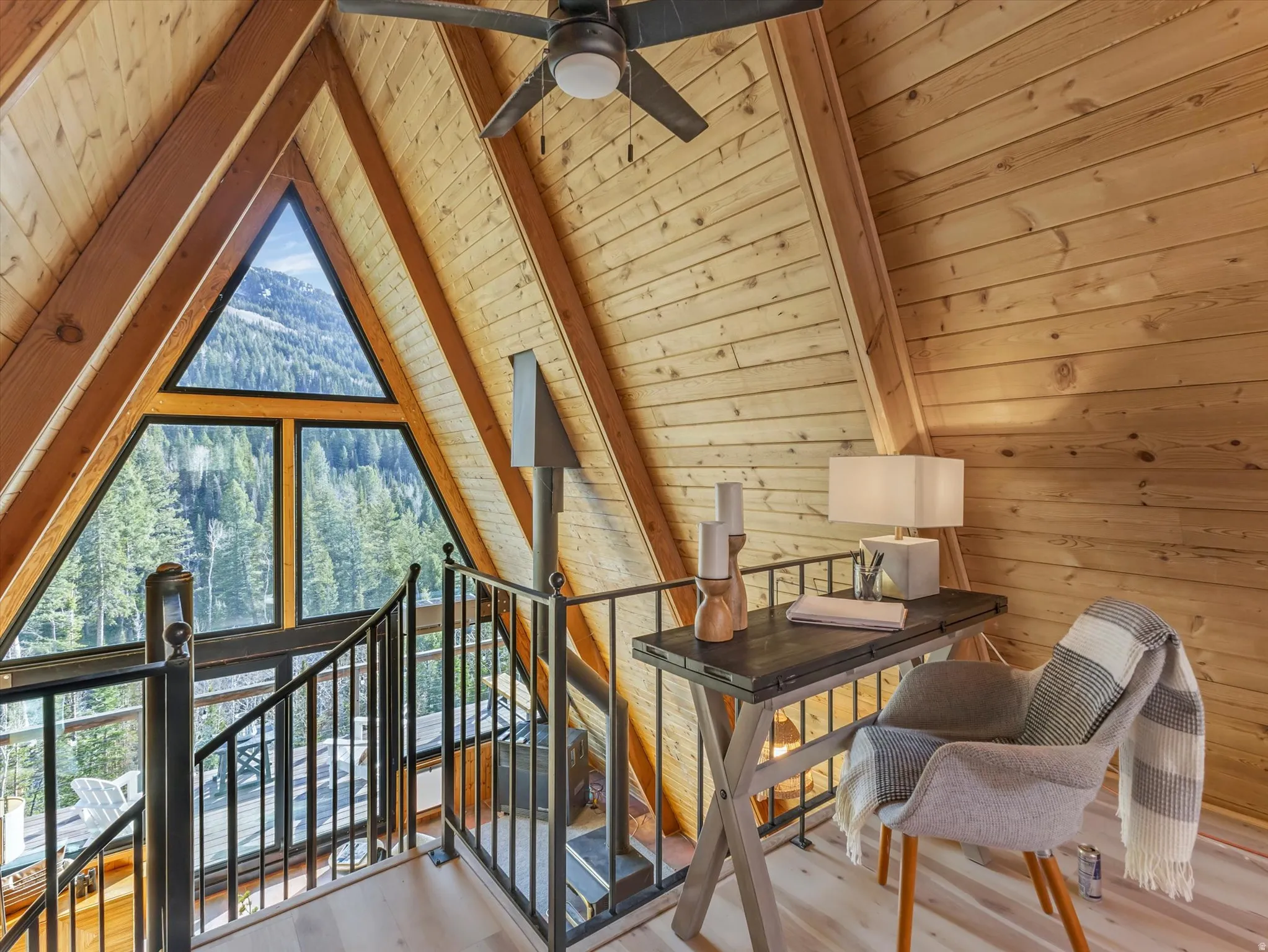 Additional living space with a wooden ceiling with exposed beams, light wood-style floors, ceiling fan, and wooden walls