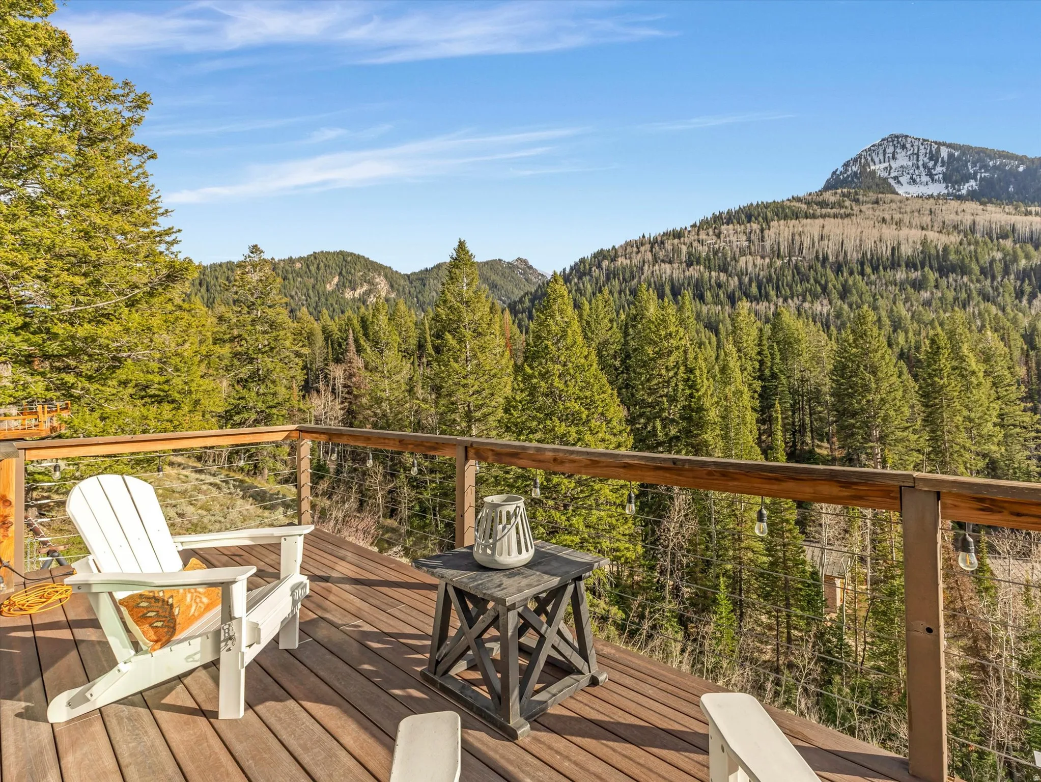 Wooden deck featuring a forest view and a mountain view
