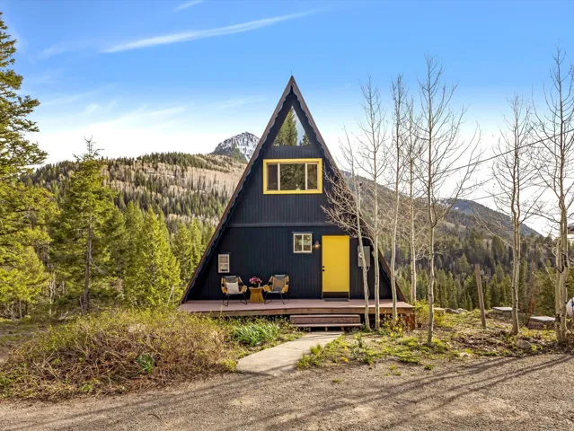 View of front facade featuring a view of trees and a deck with mountain view