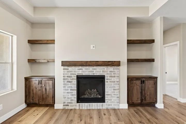 Central fireplace with light gray brick surround and wood mantel