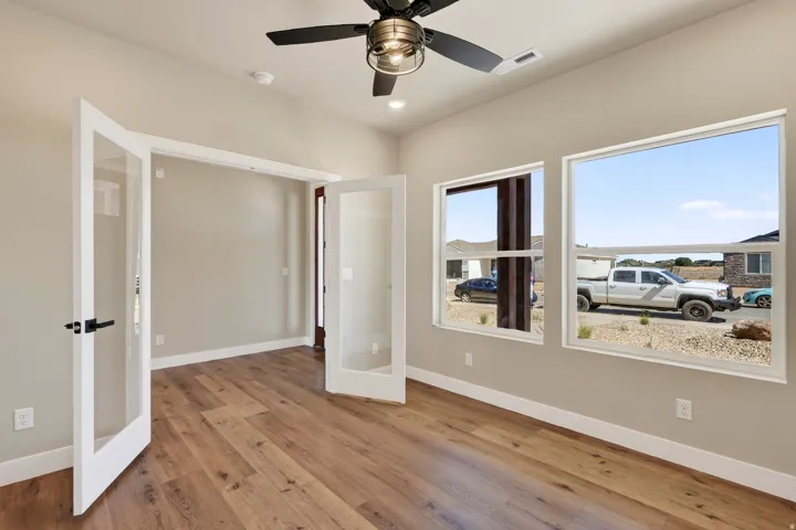 Room featuring wood-finish flooring, neutral wall paint, and white baseboards