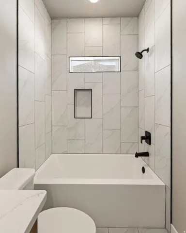 Modern bathroom featuring a built-in tub and shower with matte black fixtures