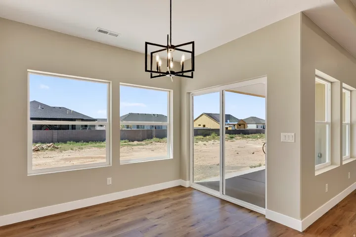 Open concept living space featuring wood-finish flooring and a contemporary black geometric chandelier