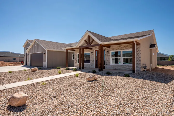 Contemporary single-story residence featuring a covered entry with timber posts, stone veneer accents, and stucco siding