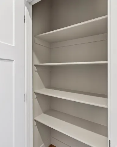 Built-in shelving unit featuring multiple painted shelves within a closet space