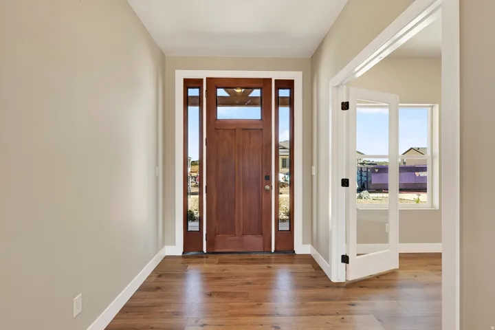 Entry foyer featuring a craftsman-style wood-paneled door with sidelight windows and a transom