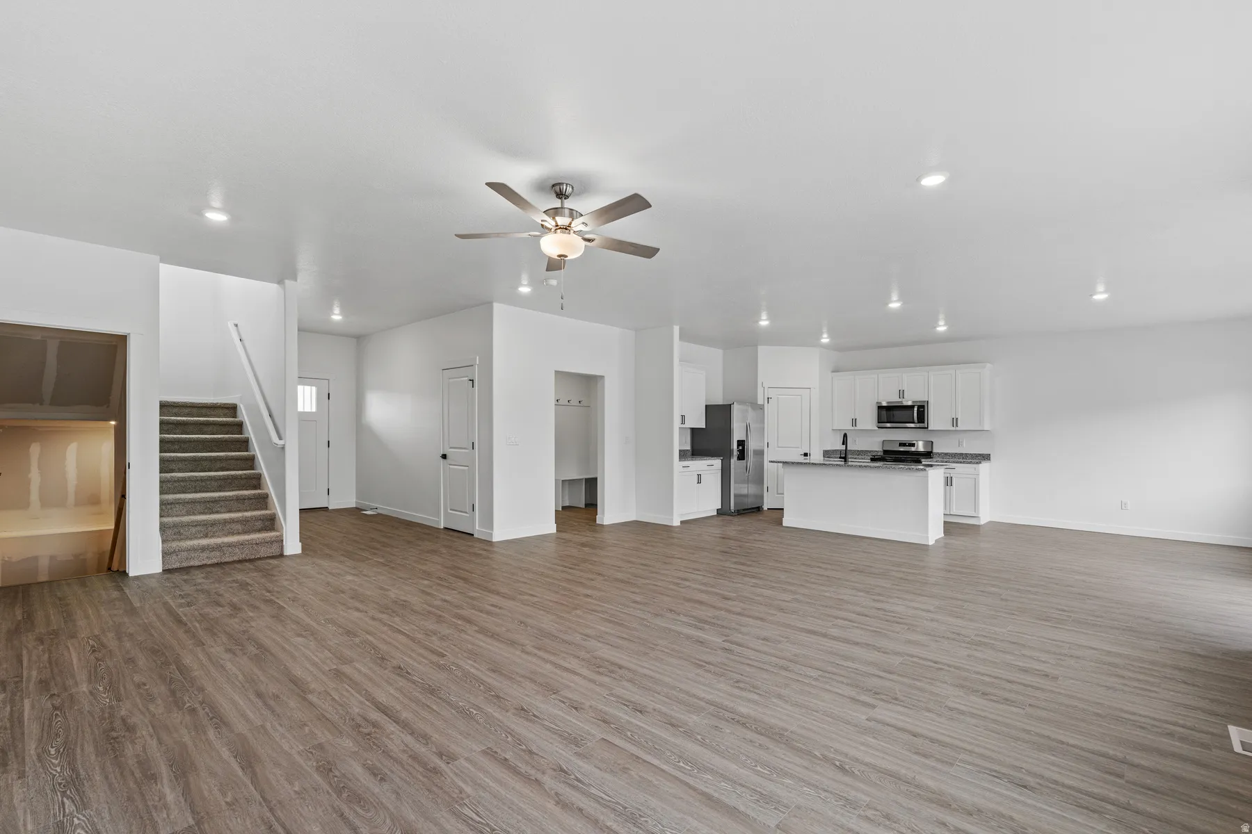 Open concept living space featuring wood-finish flooring, recessed lighting, and a ceiling fan