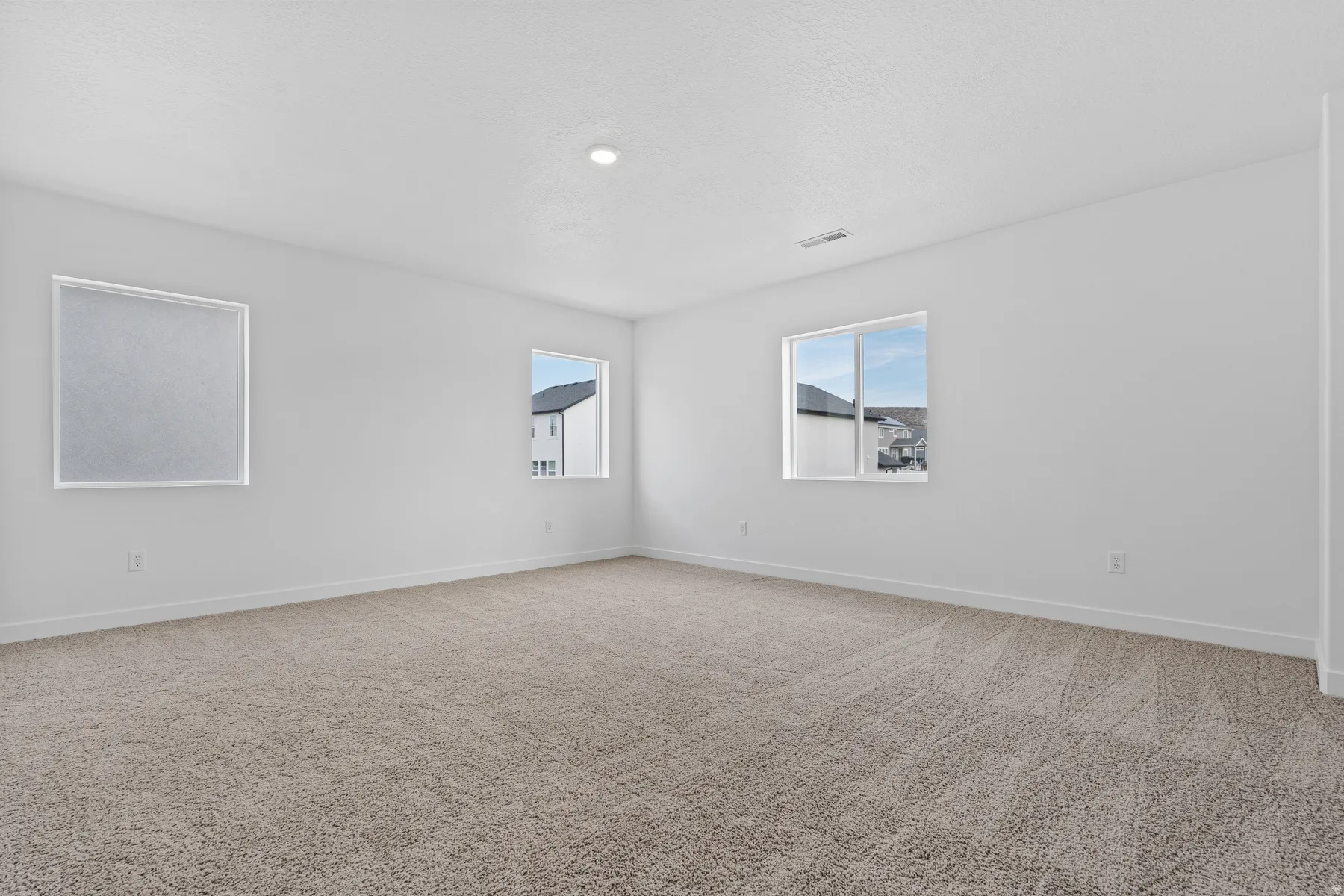 Spacious room with plush carpeting and crisp white walls
