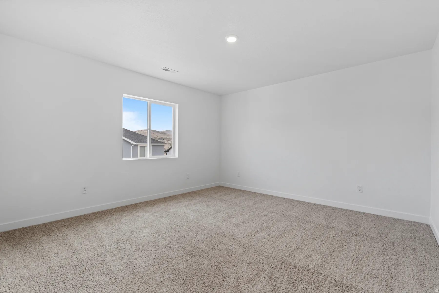 Bright room with light grey wall paint and neutral-toned carpet flooring