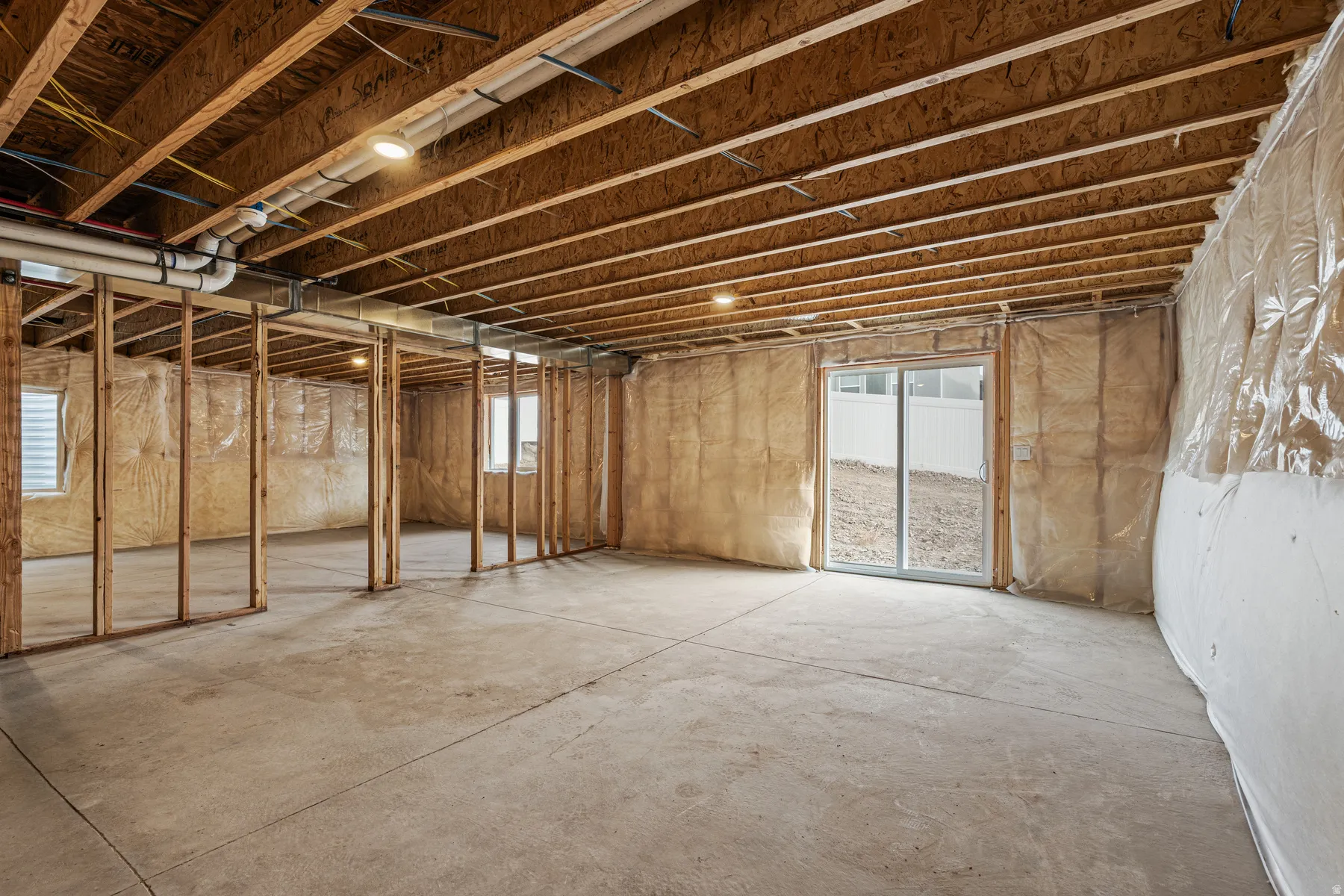Unfinished lower level featuring exposed wood joists and framing