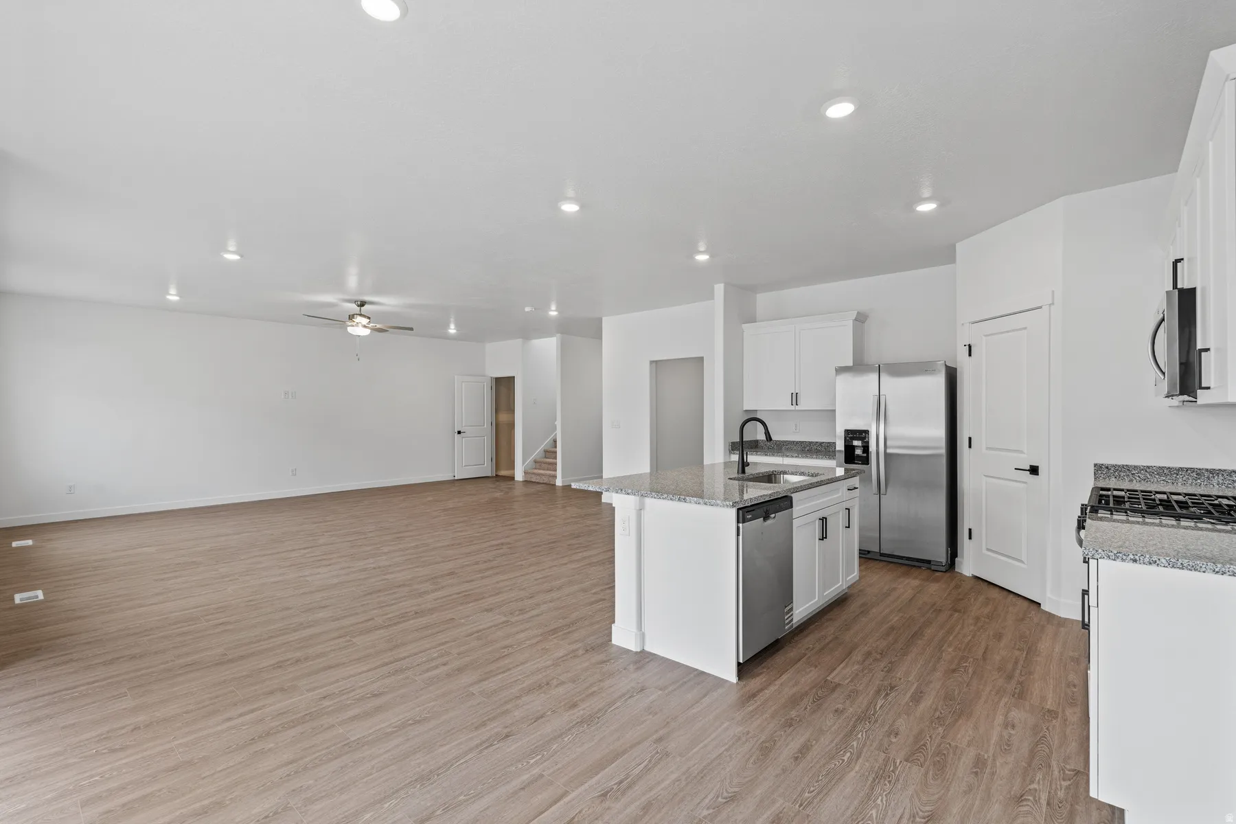 Open-concept living area with wood-finish flooring and recessed lighting