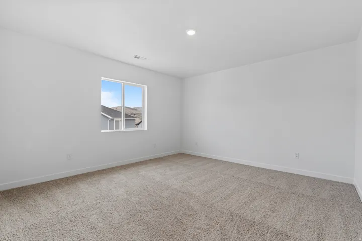 Bright room with light grey wall paint and neutral-toned carpet flooring