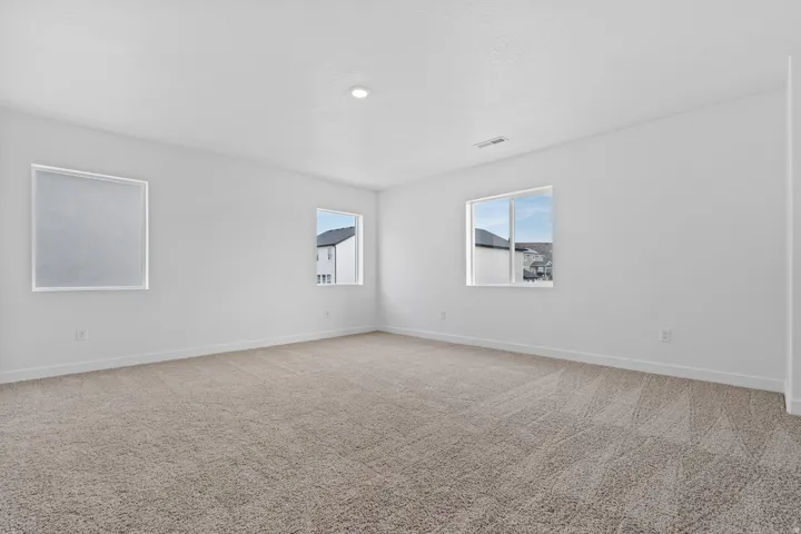 Spacious room with plush carpeting and crisp white walls