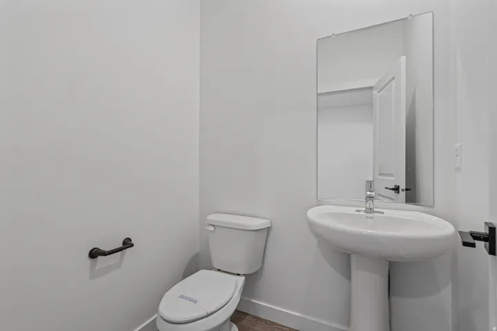 Contemporary powder room featuring a pedestal sink, rectangular mirror, and dark bronze fixtures