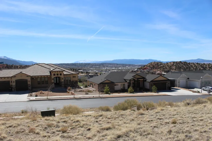 Southwestern-style residence featuring a tile roof and stucco facade with stone accents