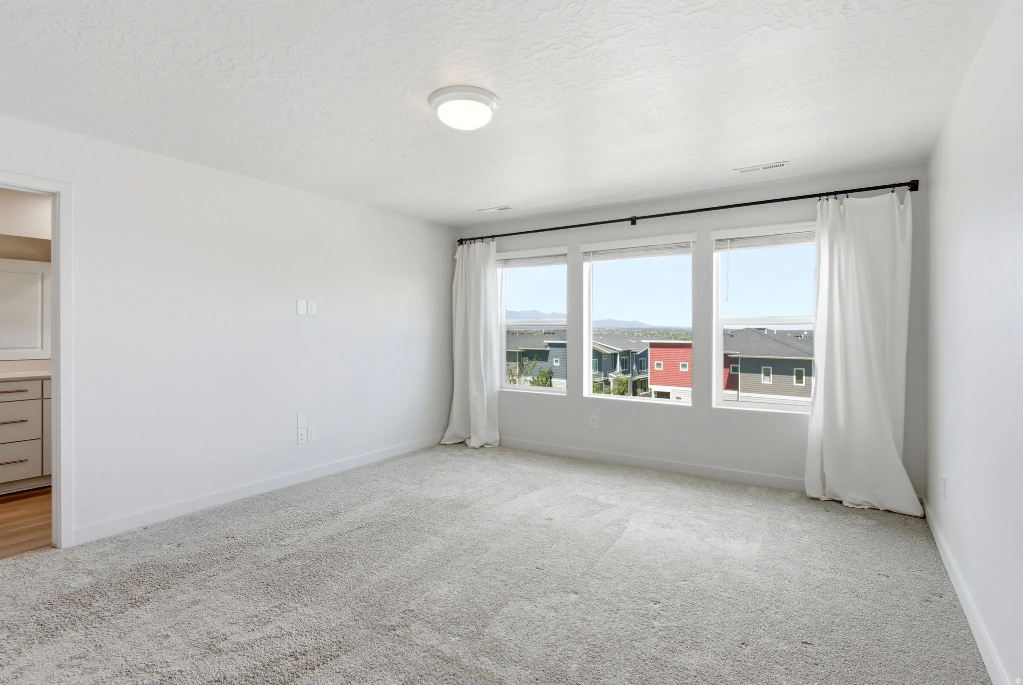 Bright interior space with light-toned carpet flooring and a neutral color palette