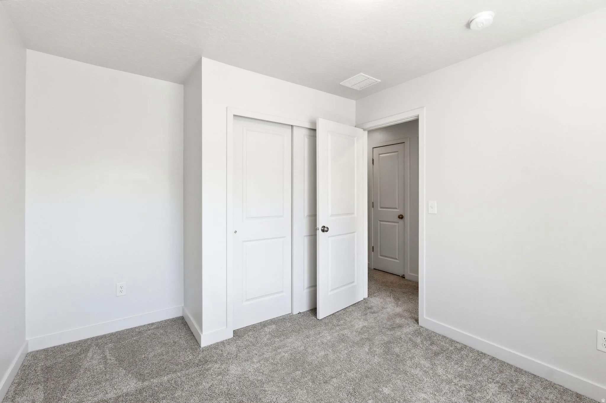 Room featuring light gray carpet flooring and white painted walls