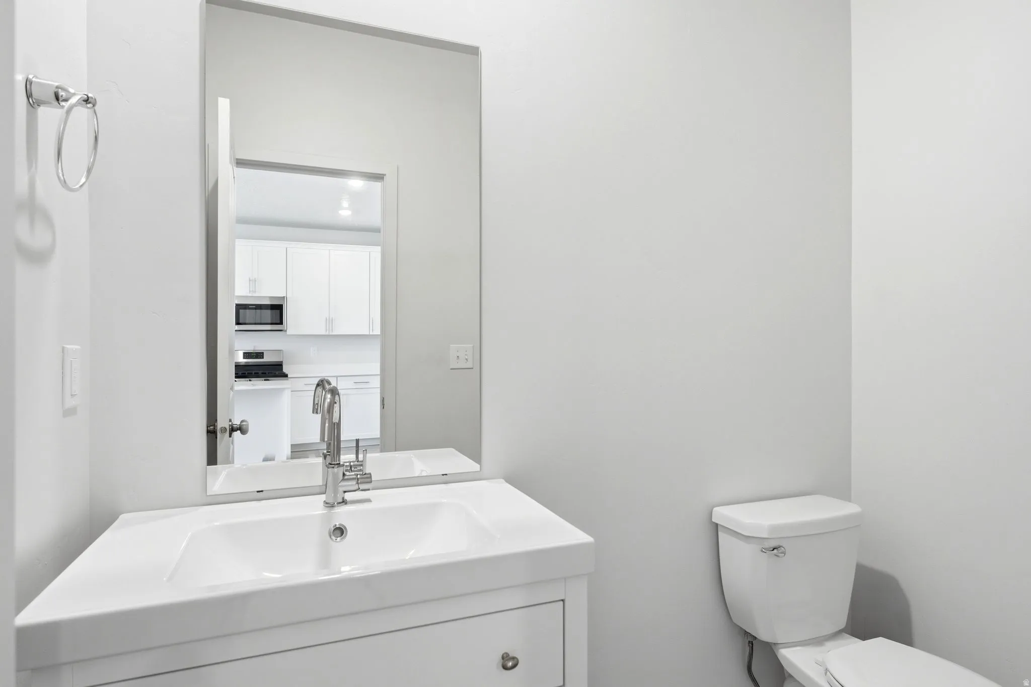 Bathroom vanity with integrated sink, chrome faucet, and rectangular mirror