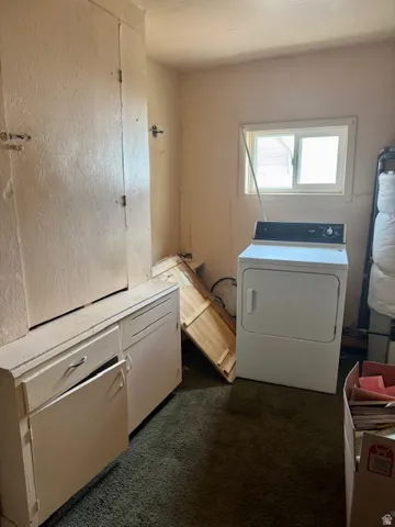 Utility room featuring a window, built-in cabinetry, and wall-mounted shelving