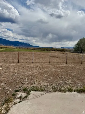 Expansive undeveloped land with distant mountain ranges and scattered green foliage