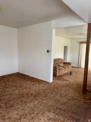 Broadloom carpeting with wood-finish flooring accents, featuring white walls and a ceiling fan