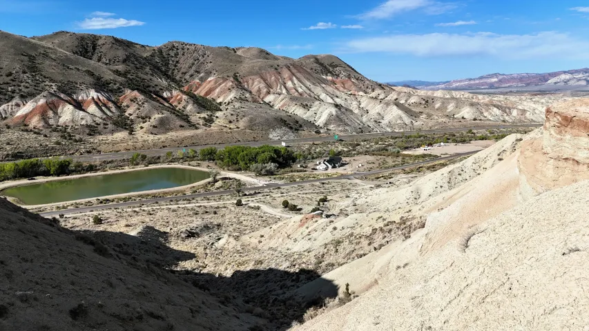 Expansive landscape featuring colorful geological formations and a prominent body of water