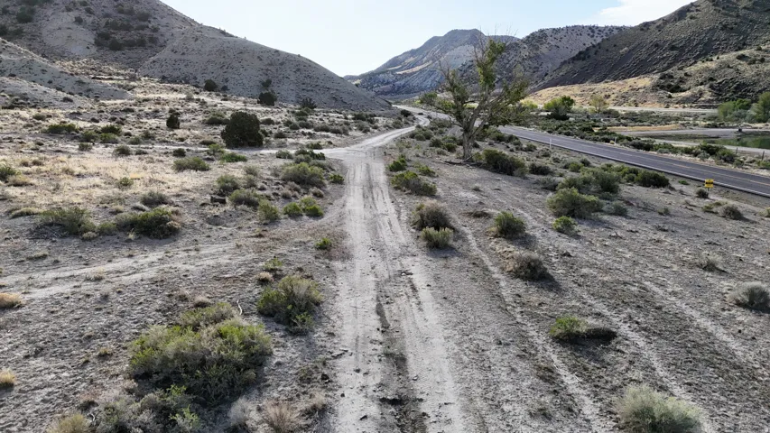 Dirt road traversing a rugged landscape with sparse vegetation