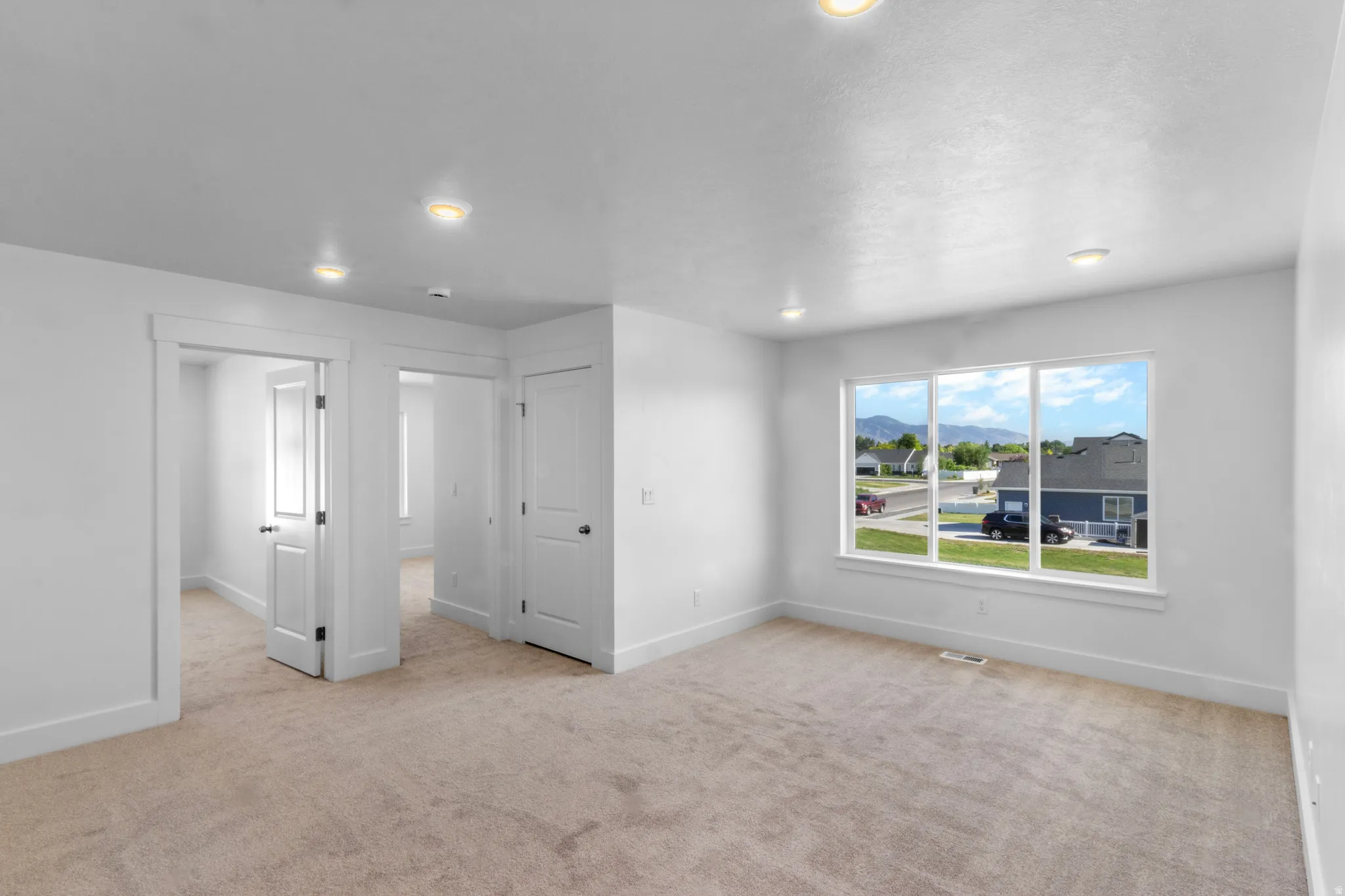 Spacious room featuring neutral carpeting and recessed lighting