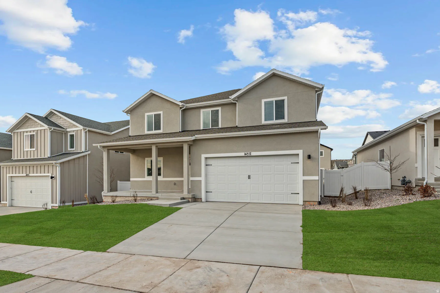 Contemporary two-story residence with a covered porch entry, an attached two-car garage, and a concrete driveway