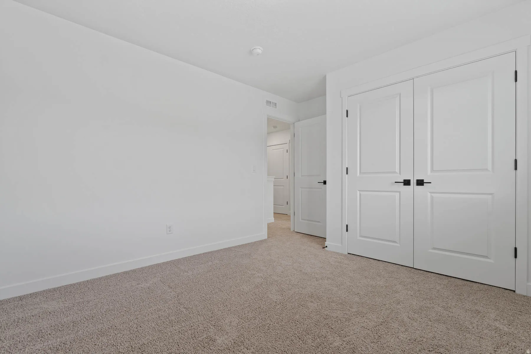Neutral tone wall finishes, soft carpet flooring, and white trim