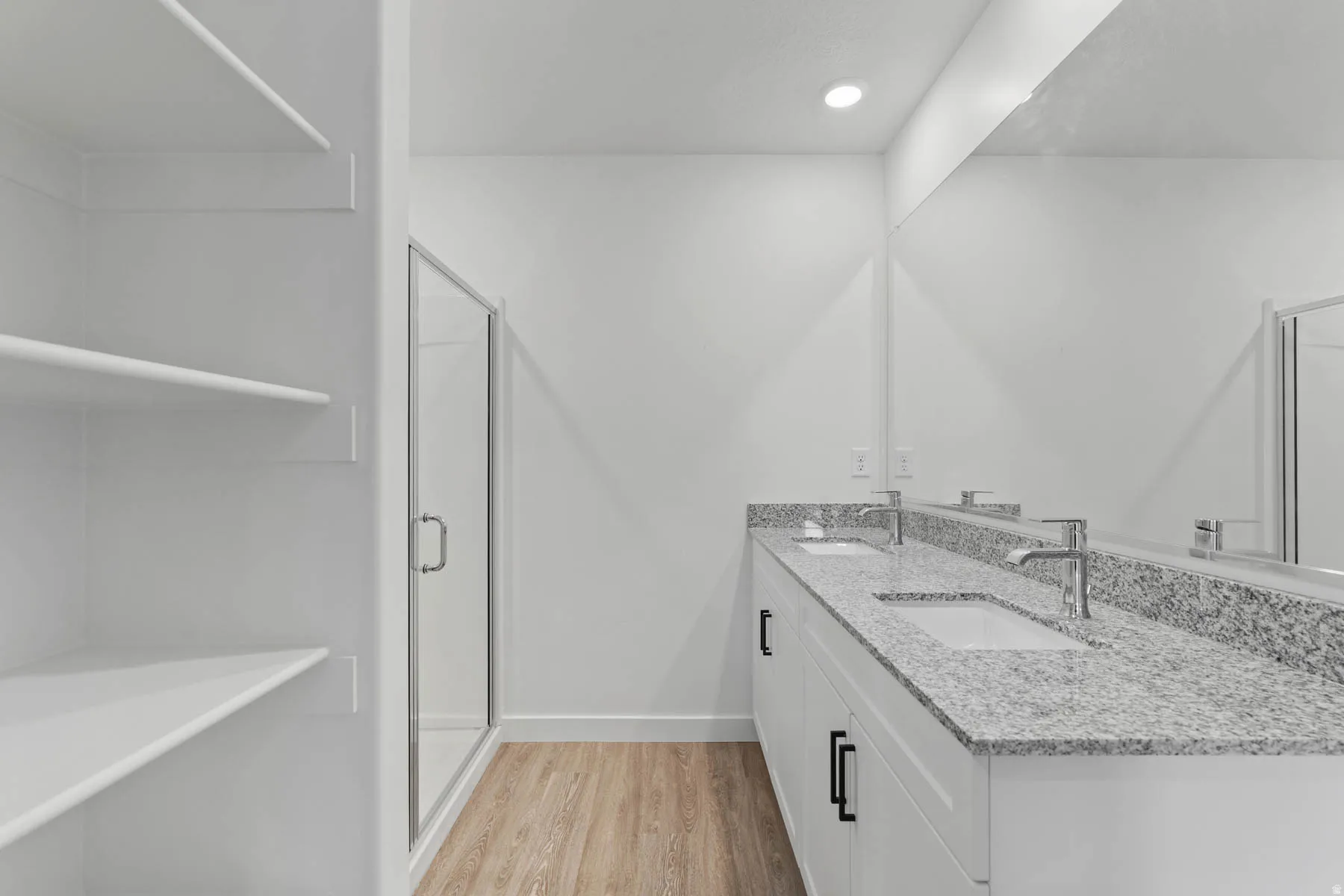 Dual vanity with granite countertops, undermount sinks, and chrome fixtures