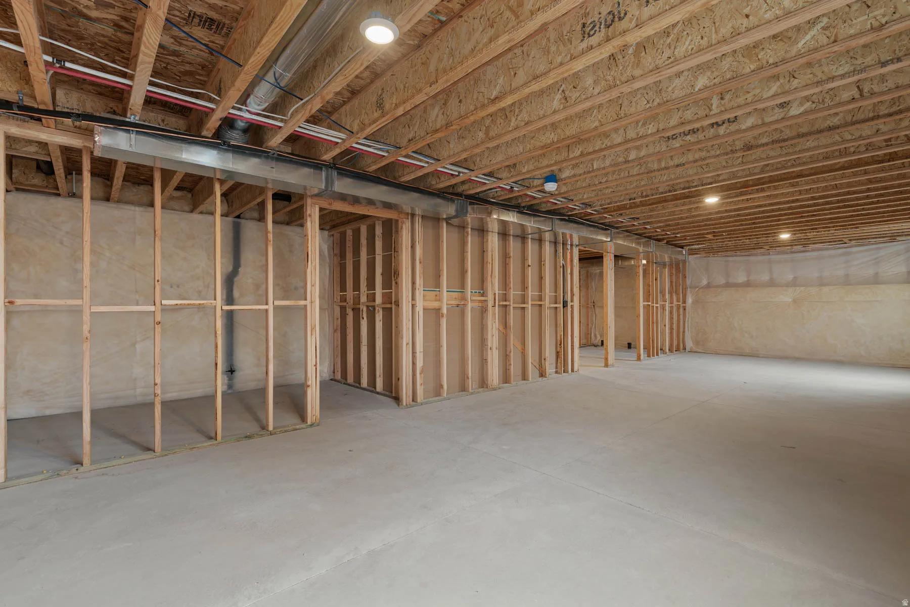 Unfinished basement featuring extensive wood framing, concrete flooring, exposed ceiling joists, and recessed lighting