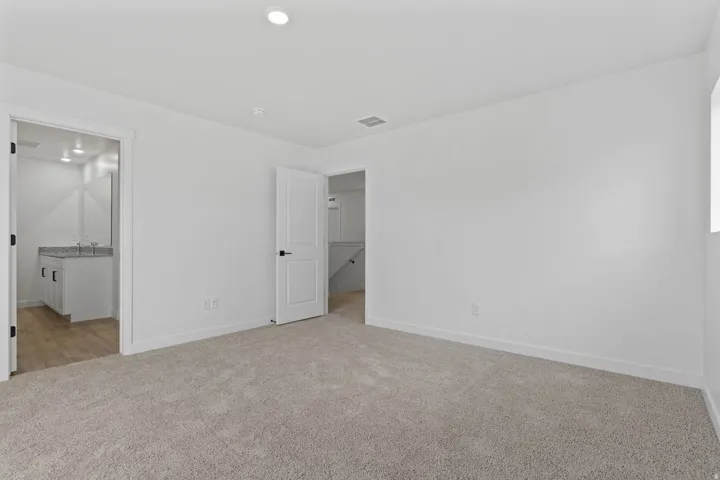 Spacious room featuring neutral carpeting and white walls