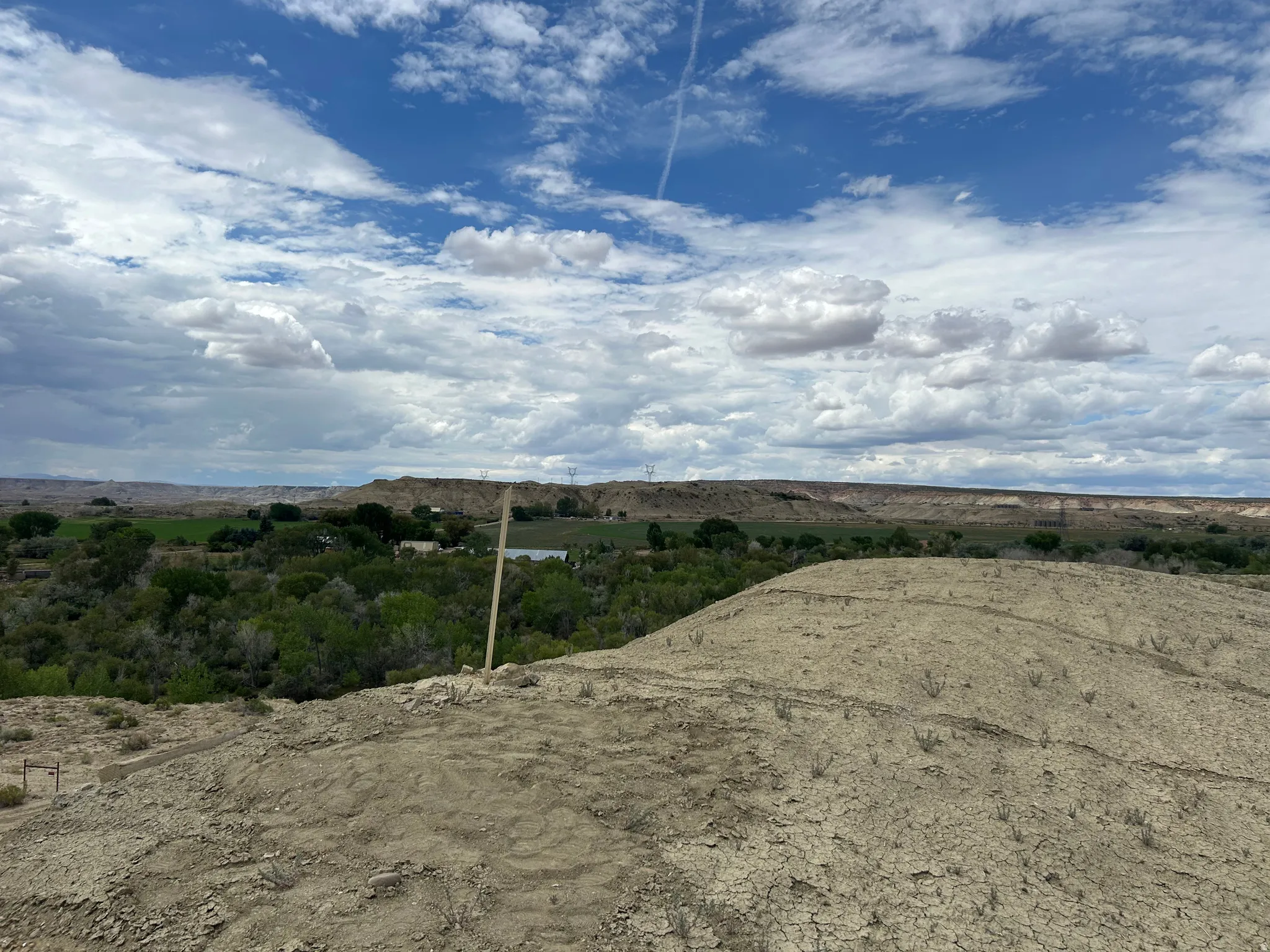 Vast open landscape featuring a diverse topography of arid terrain and distant green spaces