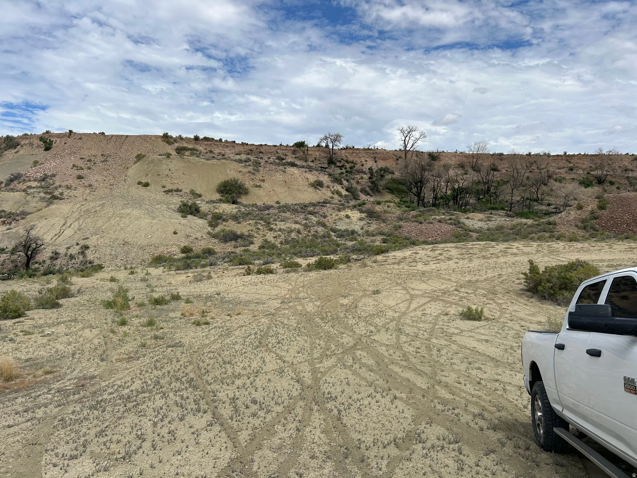 Expansive natural landscape featuring rolling hills and sparse vegetation