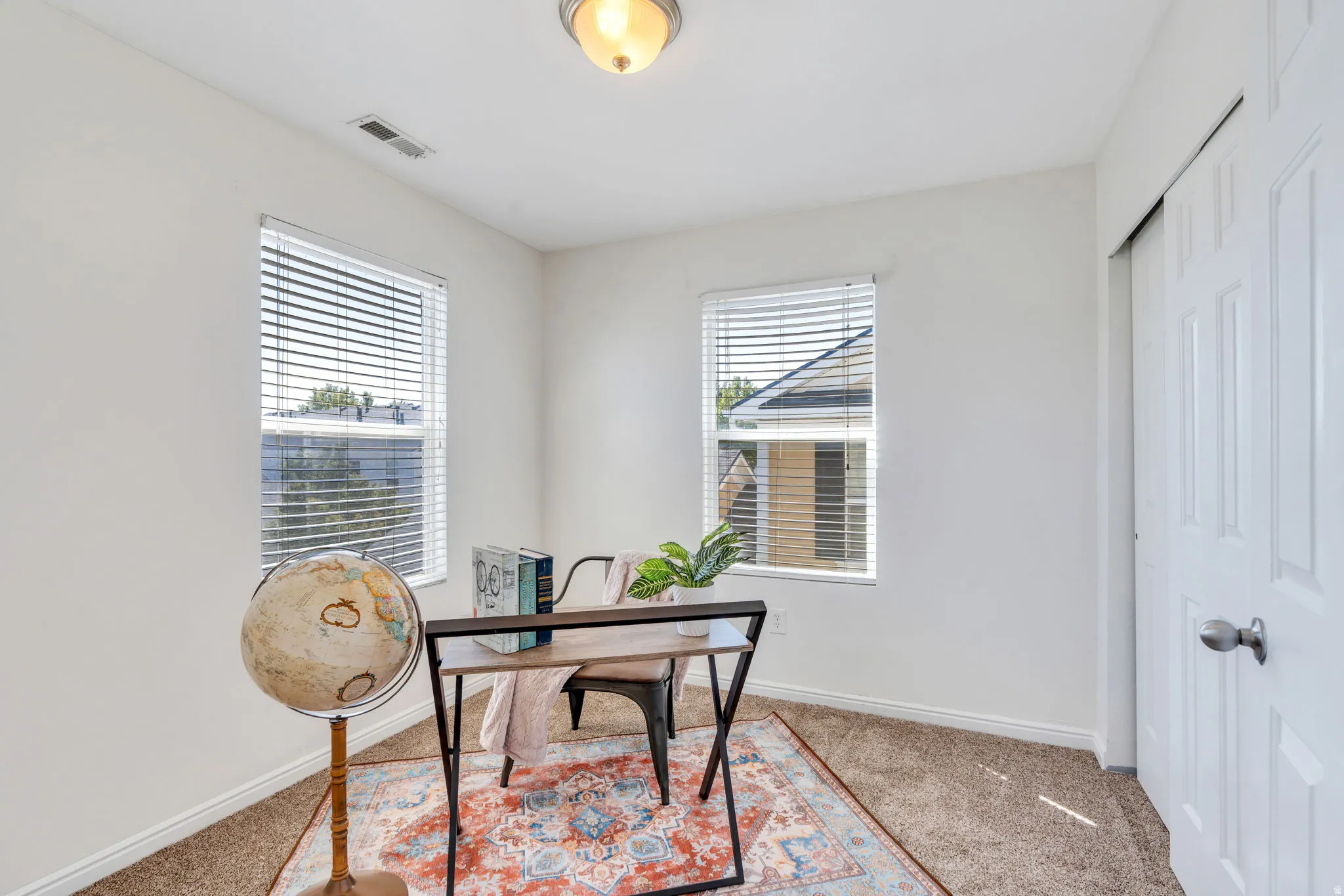 Office space with light carpet and baseboards