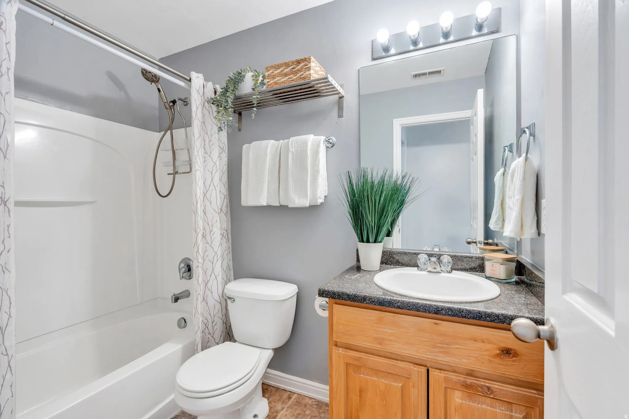 Bathroom with shower / bathtub combination with curtain and vanity